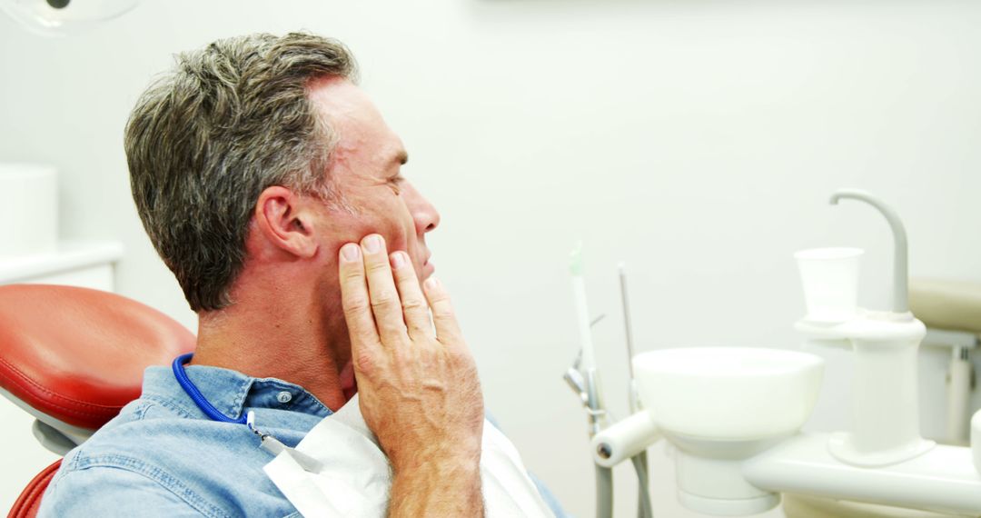 Middle-aged Man Experiencing Tooth Pain at Dental Clinic - Free Images, Stock Photos and Pictures on Pikwizard.com