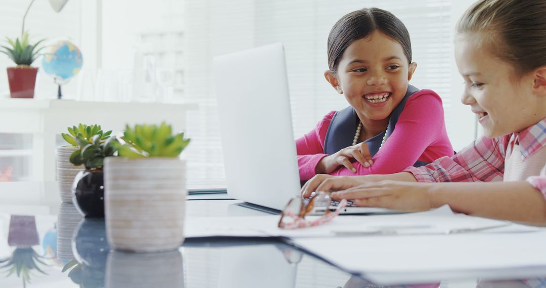 Two Young Girls Laughing While Using Laptop in Classroom - Free Images, Stock Photos and Pictures on Pikwizard.com