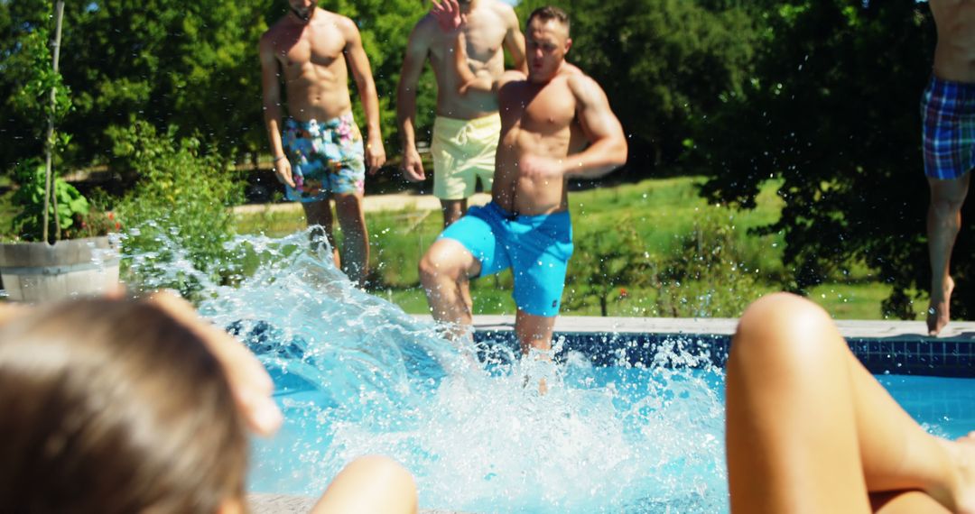 A lively group relishes summer by the pool as a man in blue shorts dives in. - Free Images, Stock Photos and Pictures on Pikwizard.com