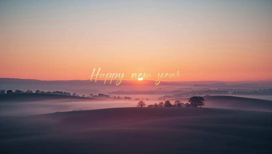 Golden Sunrise Over Misty Rolling Hills With 'Happy New Year' Script Overlay