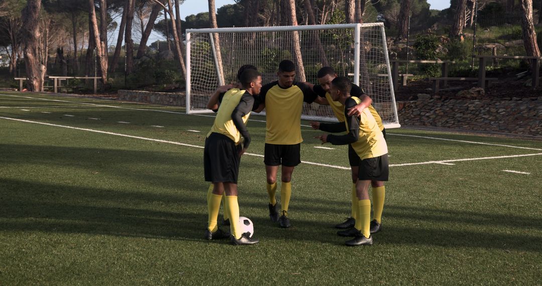 Youth Soccer Team Huddling on Field for Teamwork and Strategy