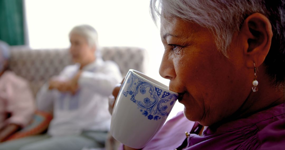 Senior Woman Enjoying Coffee with Friends in Nursing Home