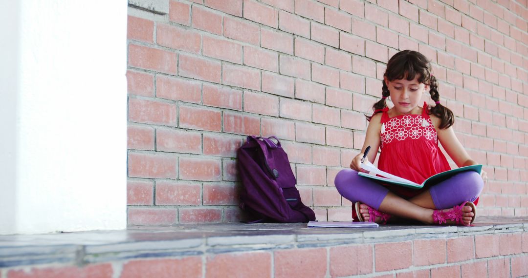 Young Girl Studying on Brick Wall - Free Images, Stock Photos and Pictures on Pikwizard.com