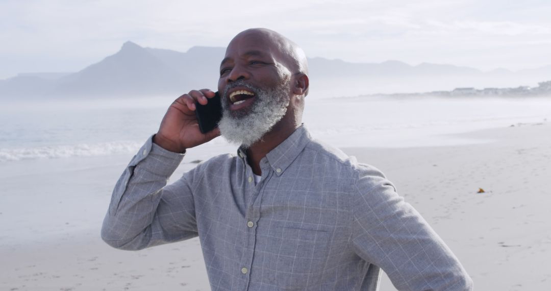 Smiling Senior Man Talking on Smartphone at Beach - Free Images, Stock Photos and Pictures on Pikwizard.com