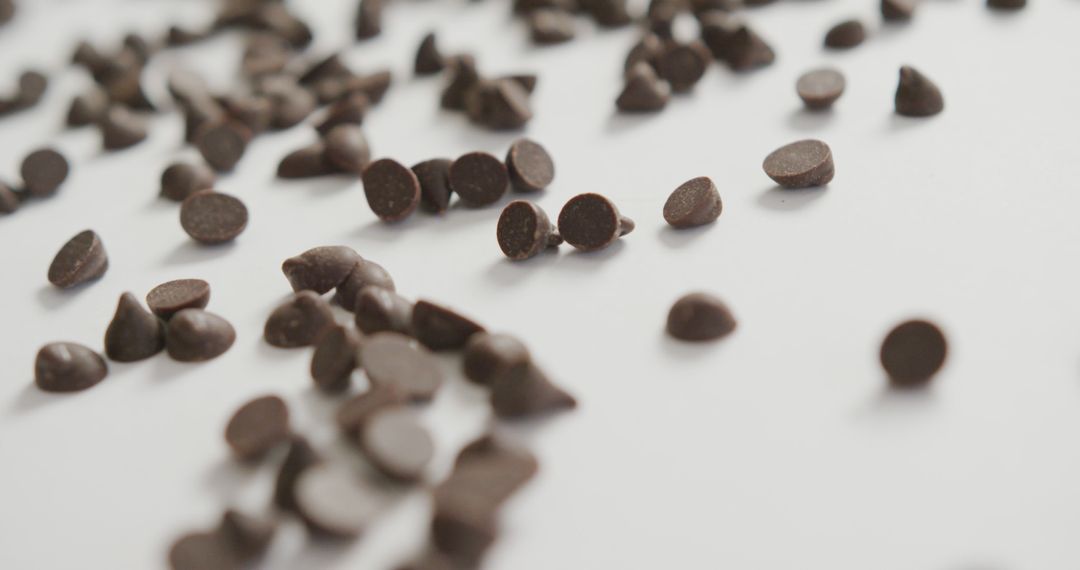 Scattered Dark Chocolate Chips on White Background - Free Images, Stock Photos and Pictures on Pikwizard.com