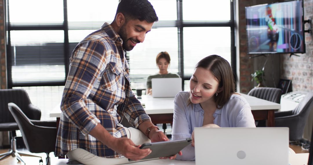 Colleagues Collaborating in Modern Office on Tablet