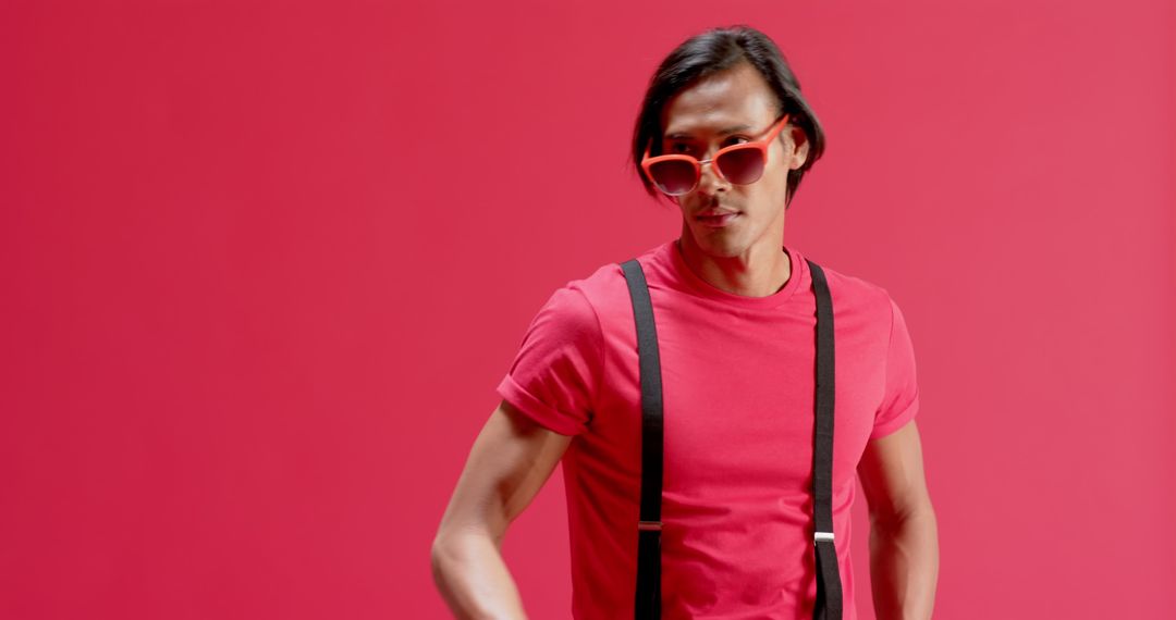 Stylish Man in Red with Suspenders Against Bold Studio Backdrop