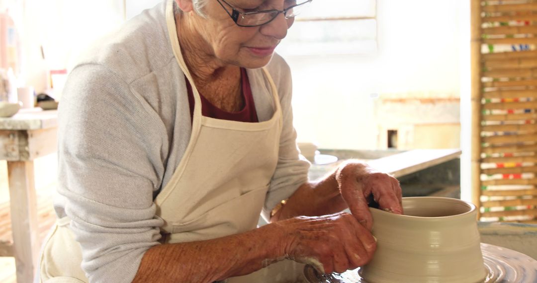 Elderly Woman Crafting Pottery on Wheel in Studio - Free Images, Stock Photos and Pictures on Pikwizard.com