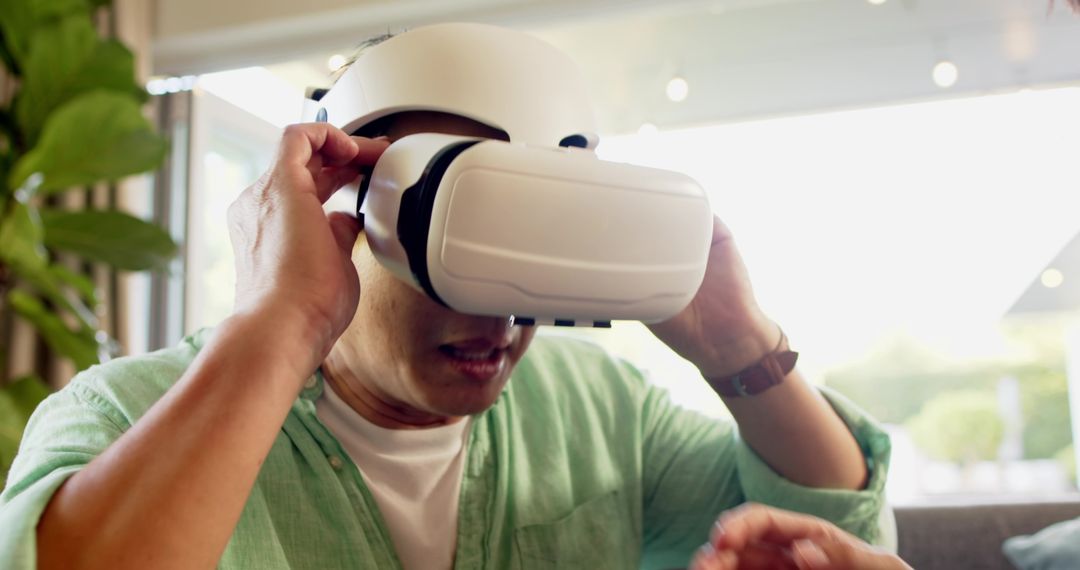 Father Experiencing Virtual Reality at Home with Son's Assistance