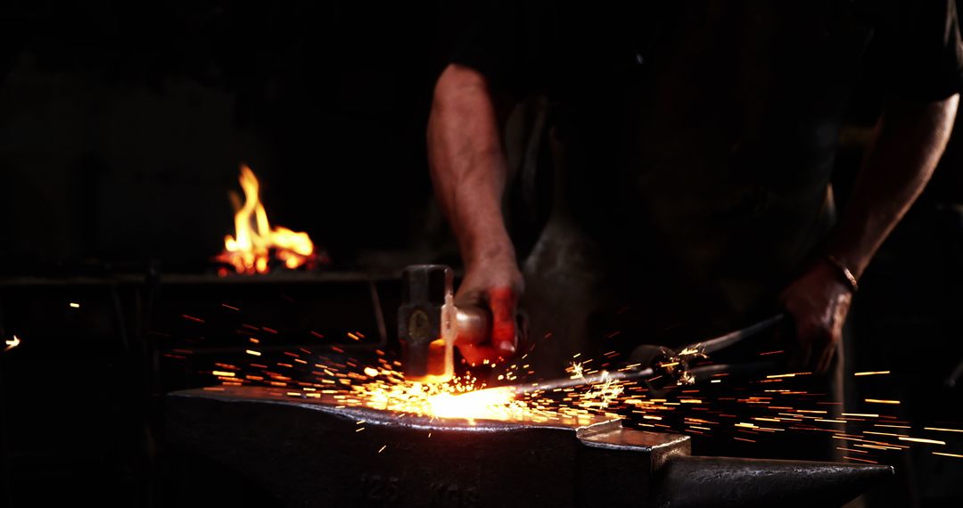 Blacksmith Hammering Glowing Metal with Sparks