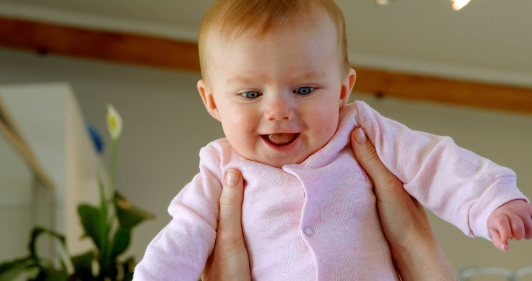 Smiling Baby in Pink Onesie Being Lifted Up - Free Images, Stock Photos and Pictures on Pikwizard.com