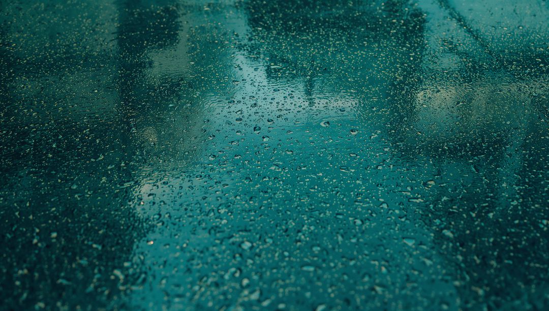 Teal Tinted Glass Panel with Shimmering Water Droplets