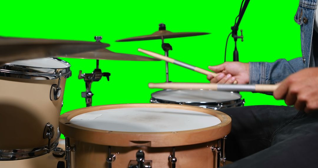 Mid section of drummer playing drum against green screen - Free Images, Stock Photos and Pictures on Pikwizard.com