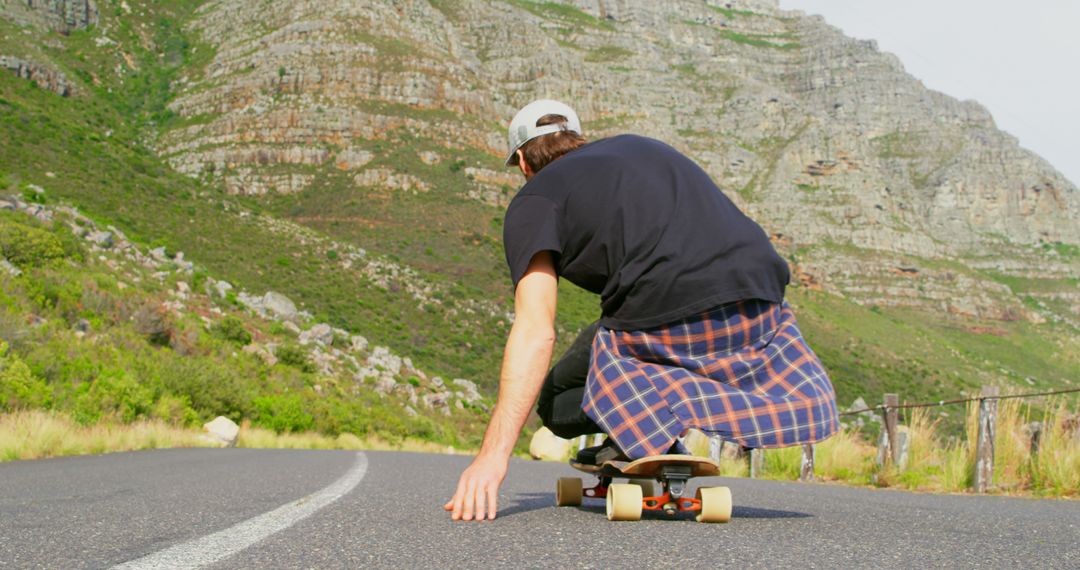 Youthful Skateboarder Riding Down Scenic Mountain Road - Free Images, Stock Photos and Pictures on Pikwizard.com