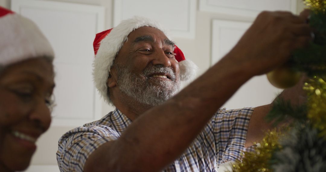 Image of happy african american senior couple decorating christmas tree together - Free Images, Stock Photos and Pictures on Pikwizard.com