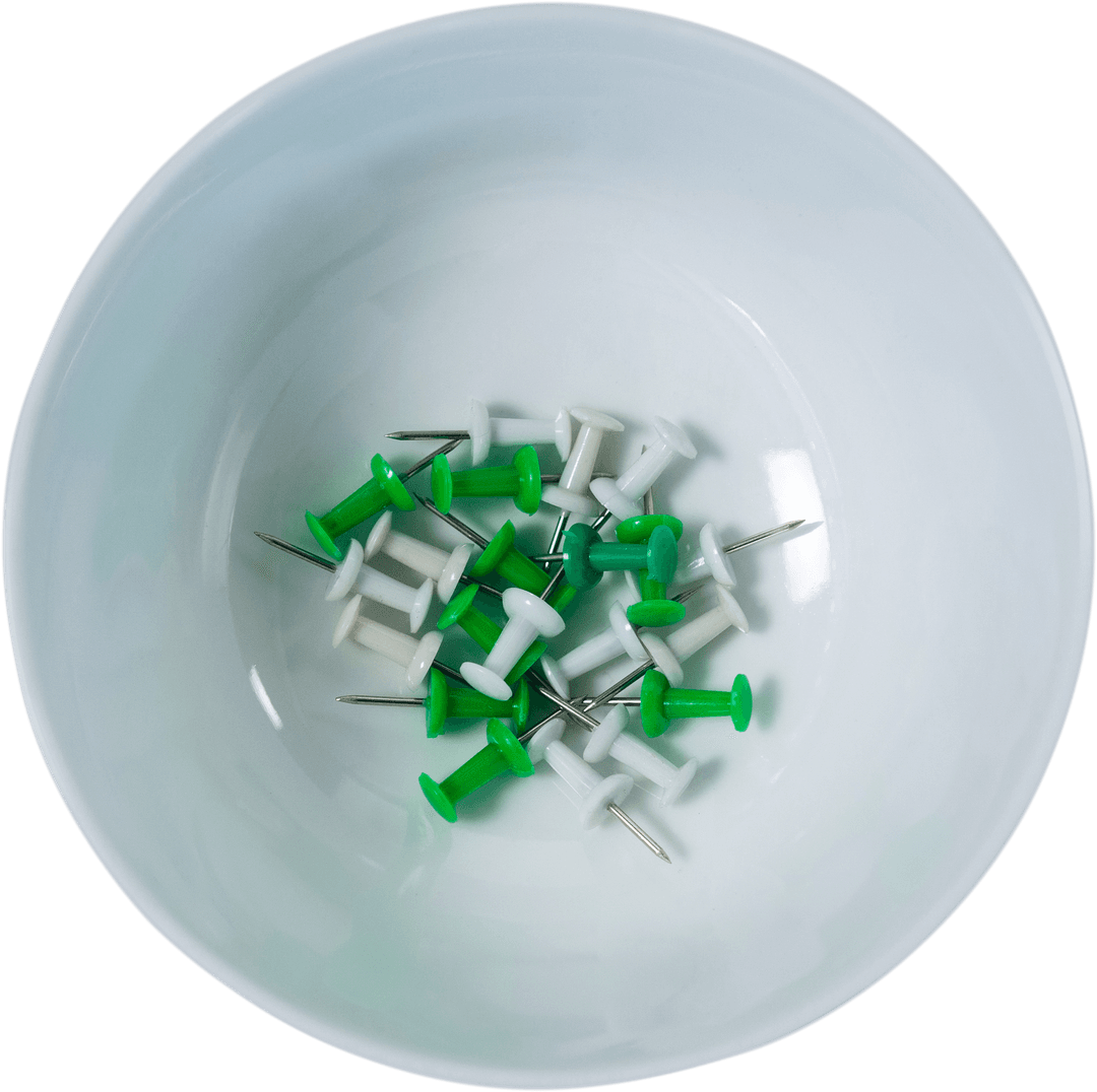 Collection of Green and White Pushpins in Transparent Bowl