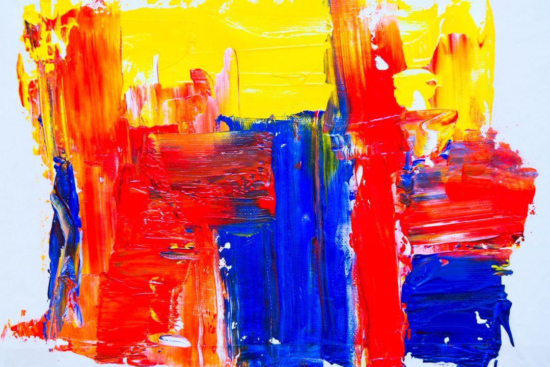 Vibrant Acrylic Brushstrokes Creating Bold Red Blue Yellow Abstract Canvas Texture