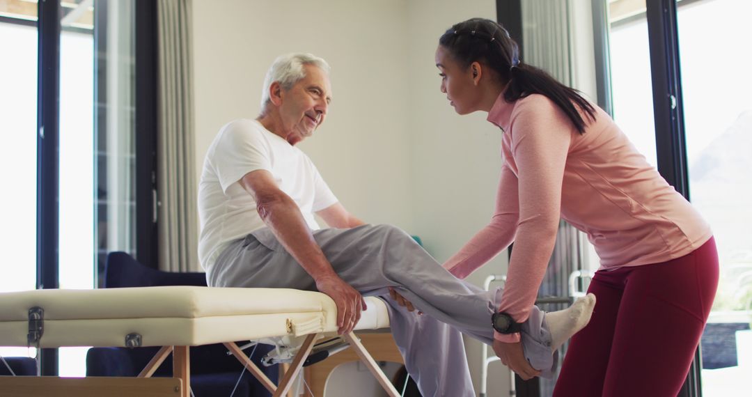 Elderly man receiving physical therapy at home with caregiver's assistance - Free Images, Stock Photos and Pictures on Pikwizard.com