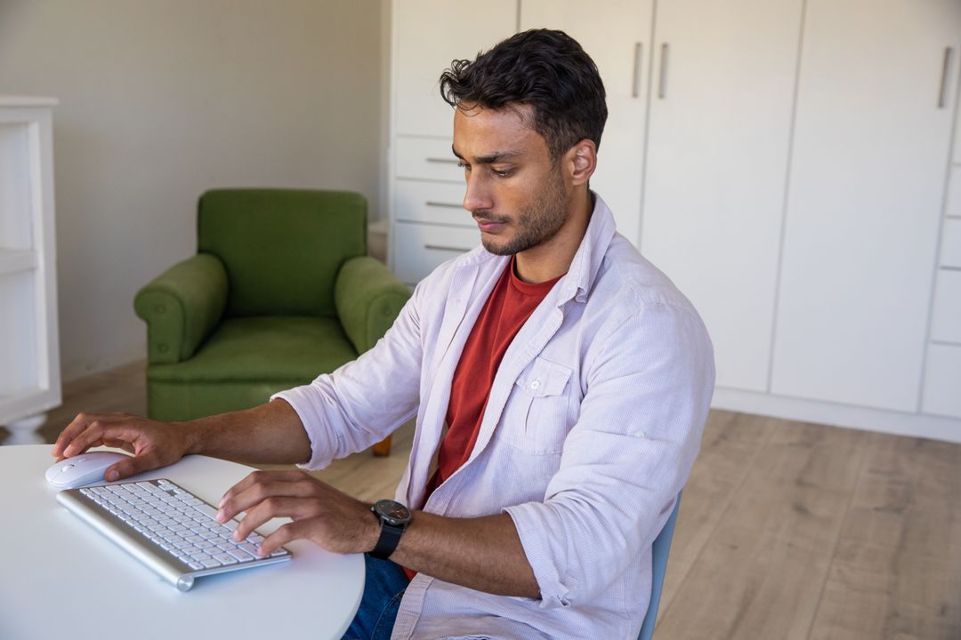 Focused Man Typing on Wireless Keyboard at Home Office