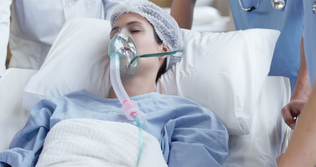 Female Patient in Hospital Bed Undergoing Treatment with Oxygen Mask - Free Images, Stock Photos and Pictures on Pikwizard.com