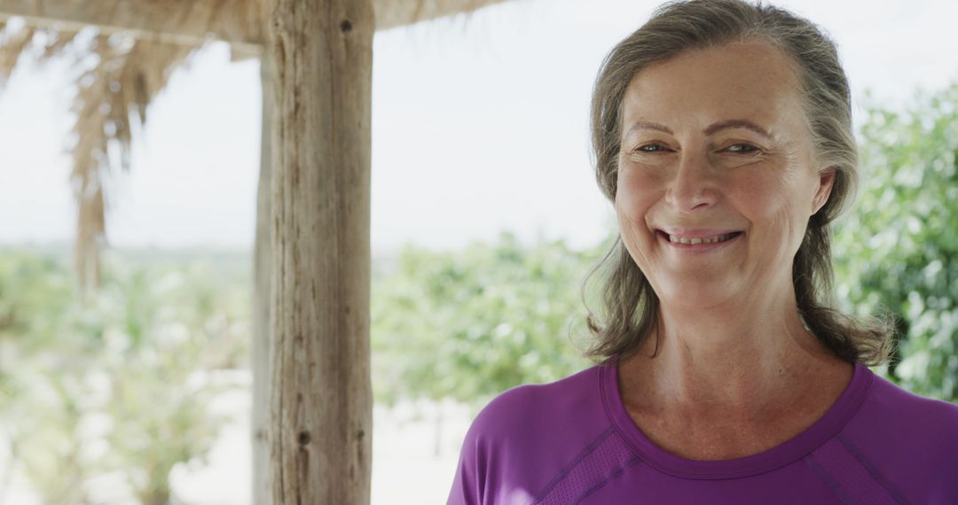 Smiling Mature Woman in Purple Shirt Outdoors on Veranda - Free Images, Stock Photos and Pictures on Pikwizard.com