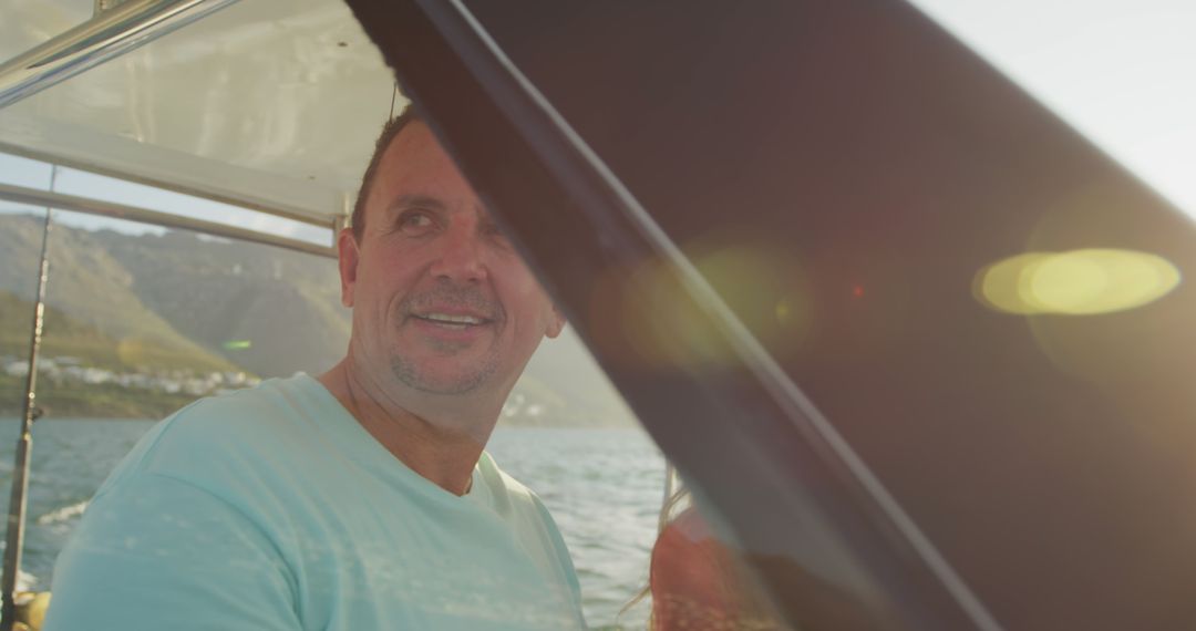 Middle-aged man enjoying boat ride under sunny sky - Free Images, Stock Photos and Pictures on Pikwizard.com