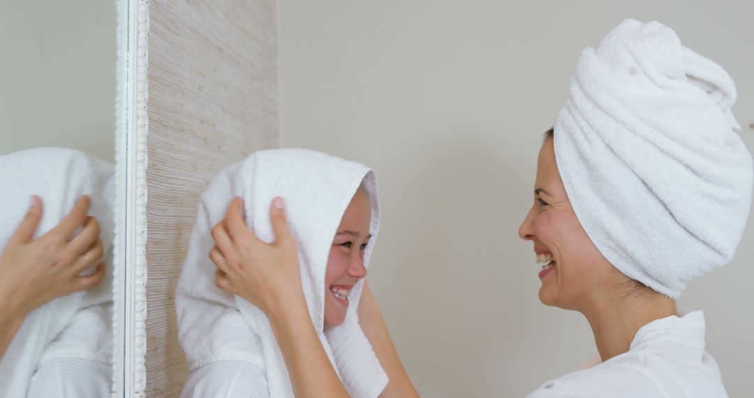 Mother and Daughter with Towels Smiling at Each Other in Bathroom - Free Images, Stock Photos and Pictures on Pikwizard.com