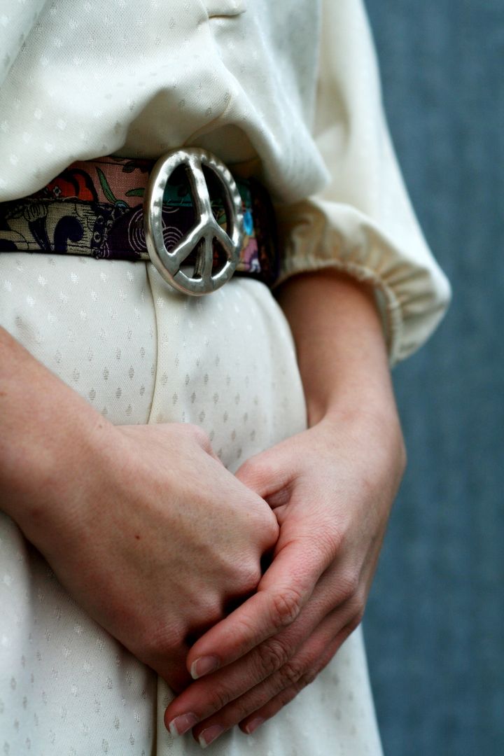 Close-Up of Person with Peace Symbol Belt Buckle