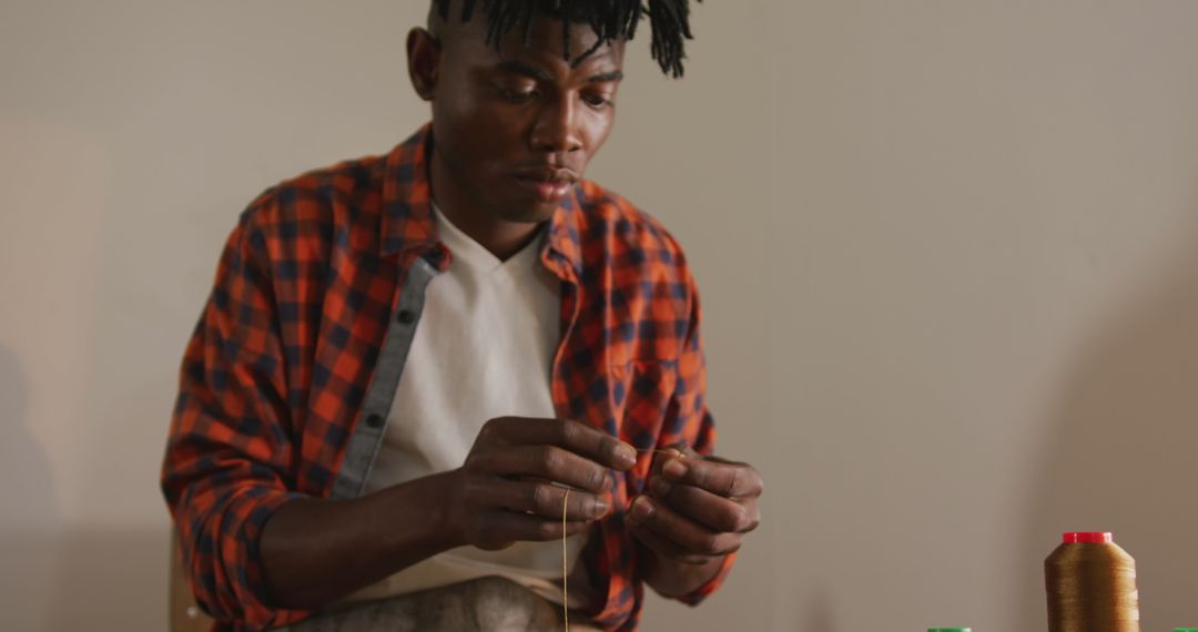 African American Craftsman Threading Needle in Artisan Workshop