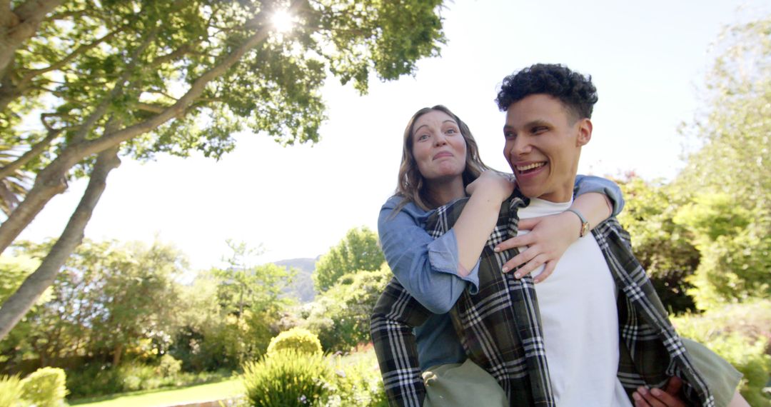 Cheerful Couple Enjoys Piggyback Ride in Lush Garden Area