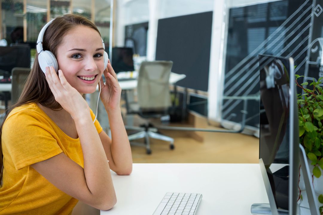 Woman in Workspace Enjoys Audio with Headphones for Concentration