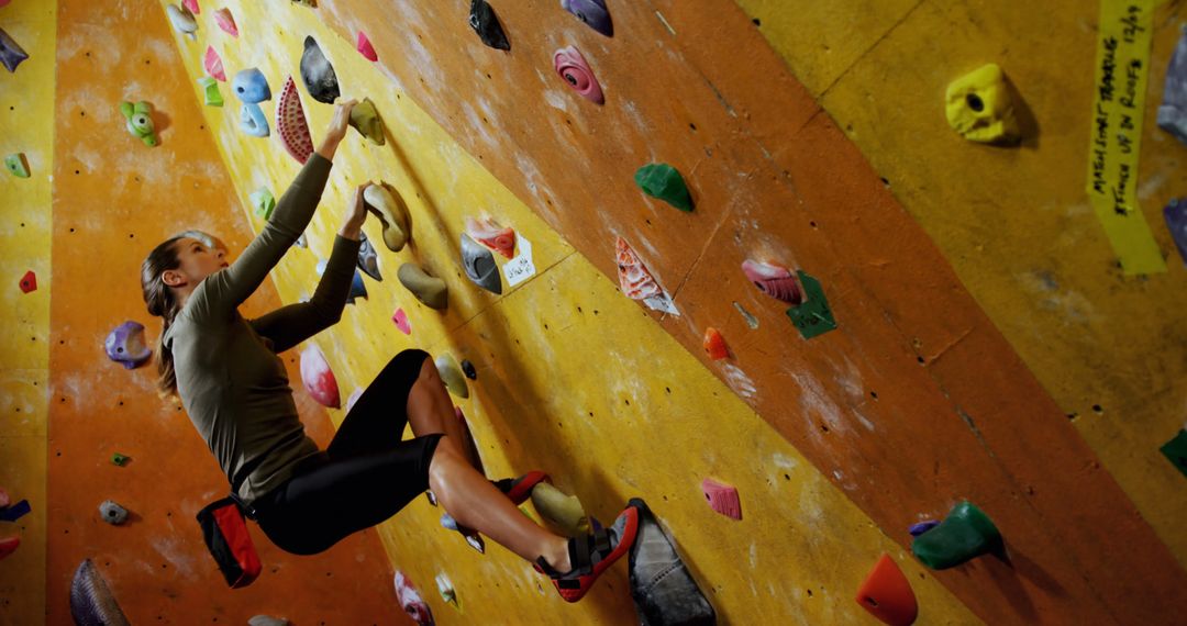 Woman Practicing Climbing on Indoor Bouldering Wall - Free Images, Stock Photos and Pictures on Pikwizard.com