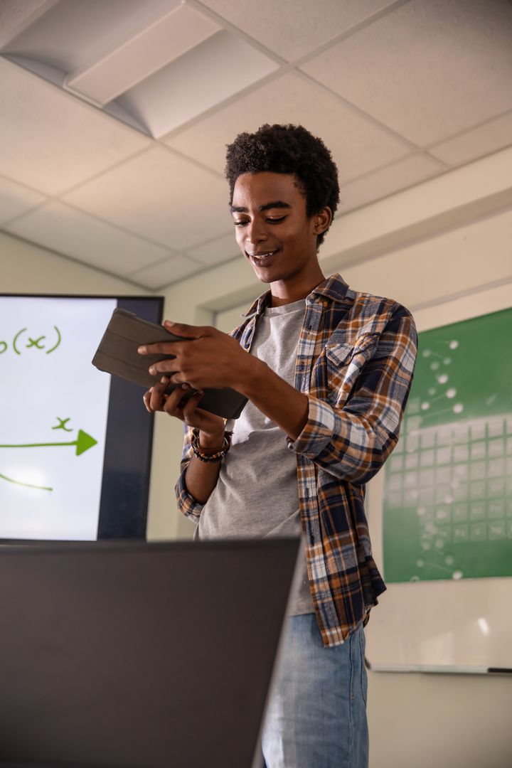 Young Man Presenting Educational Graph with Digital Devices in Classroom