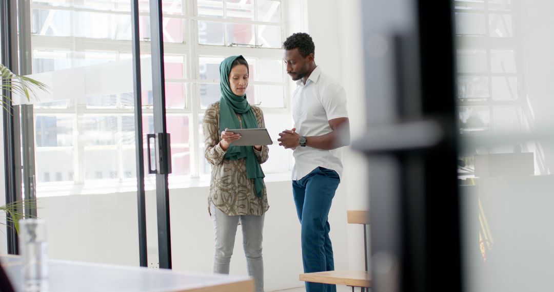 Colleagues Collaborating Using Tablet in Modern Office Setting
