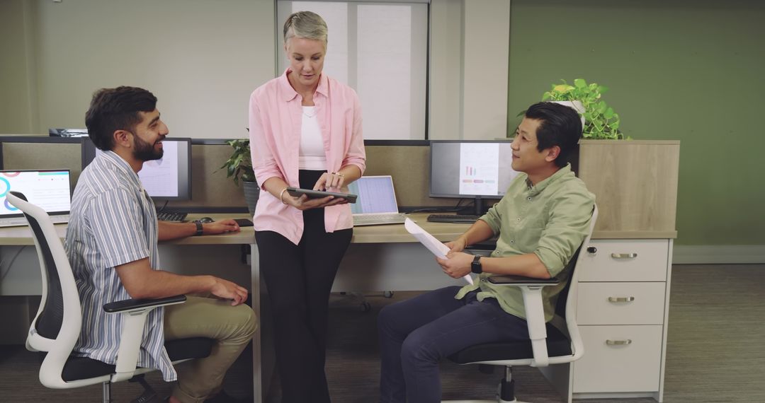 Diverse Coworkers Collaborating with Technology in Open Office