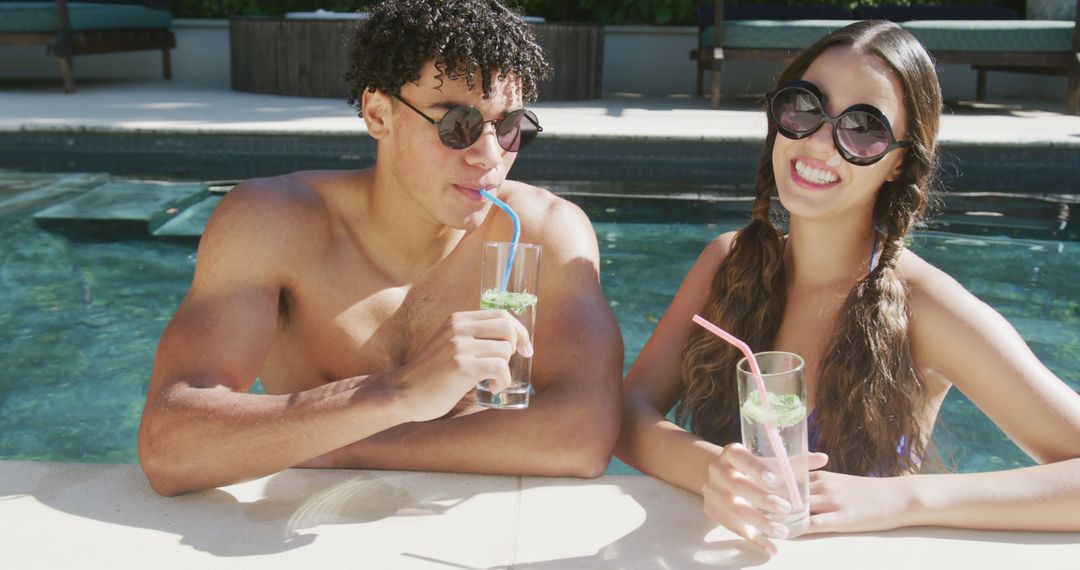 Young Couple Enjoying Refreshing Drinks in Pool on Sunny Day - Free Images, Stock Photos and Pictures on Pikwizard.com