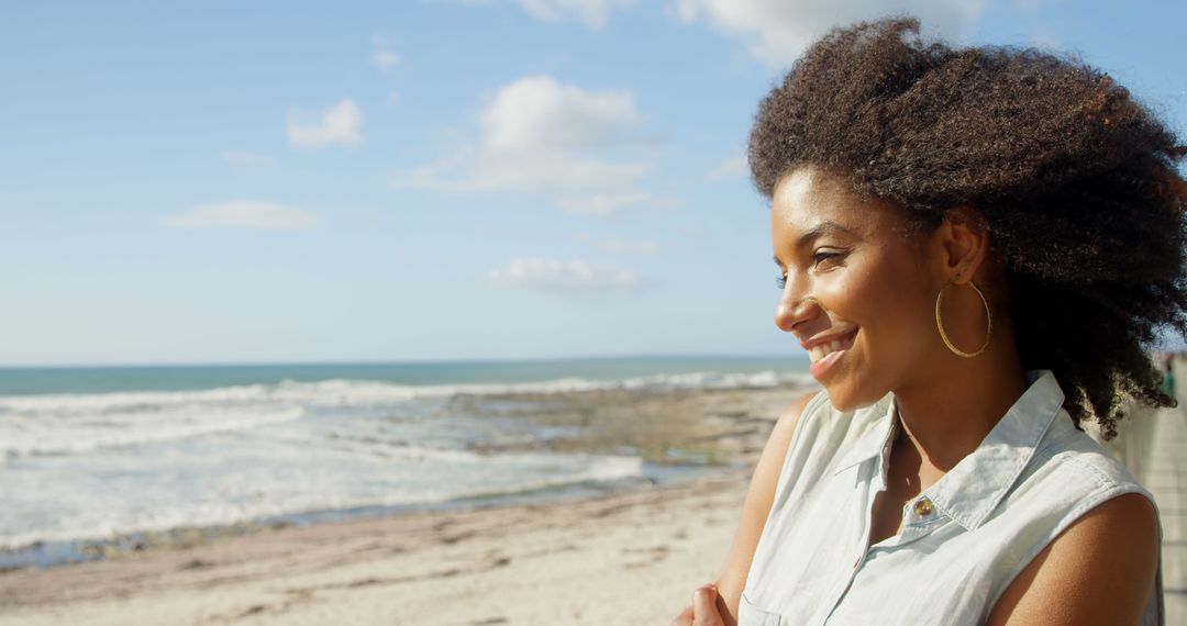 Smiling Woman with Natural Hair Enjoying Coastal View - Free Images, Stock Photos and Pictures on Pikwizard.com