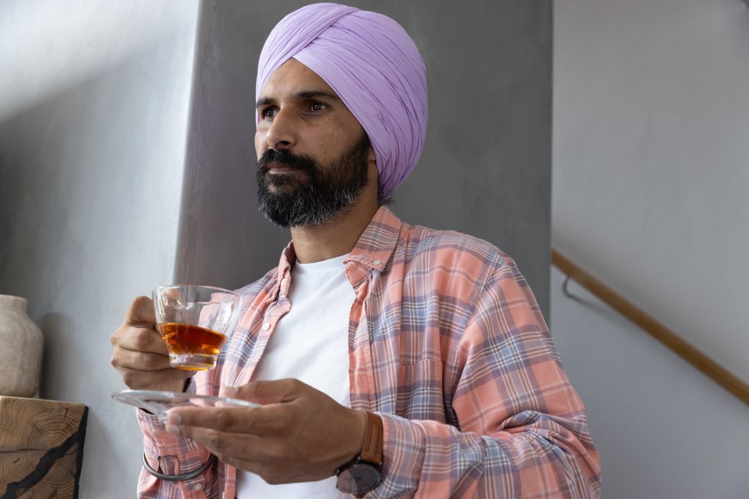 Elegant Man with Lavender Turban Enjoying Tea Indoors