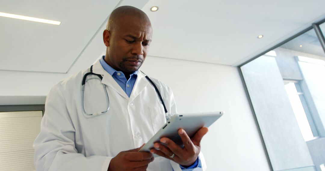 Black Male Doctor Using Digital Tablet in Modern Hospital - Free Images, Stock Photos and Pictures on Pikwizard.com