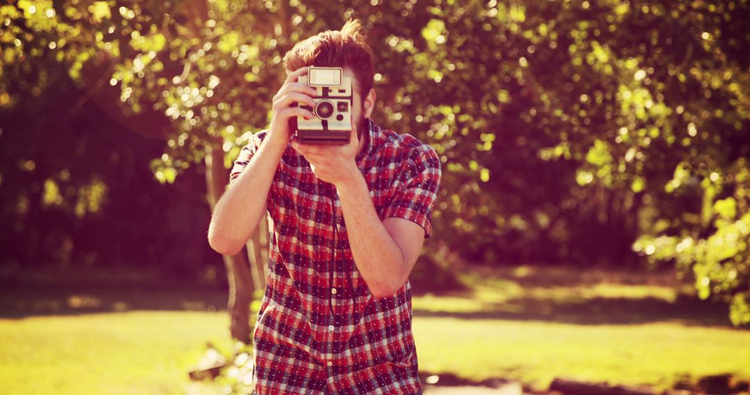 A young Caucasian man captures a moment with a vintage camera, with copy space - Free Images, Stock Photos and Pictures on Pikwizard.com
