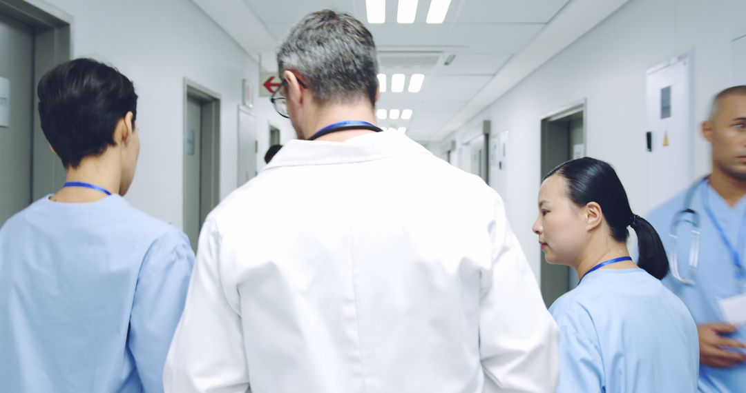 Medical Team Walking Down Hospital Hallway - Free Images, Stock Photos and Pictures on Pikwizard.com