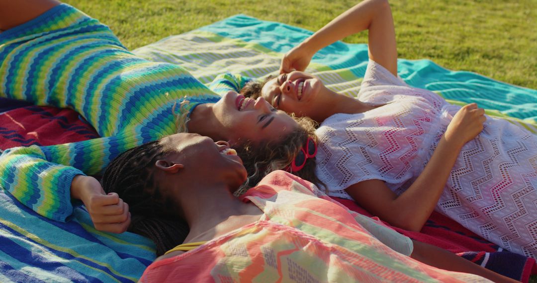 Group of Women Relaxing and Smiling on Blankets Outdoors under Sun - Free Images, Stock Photos and Pictures on Pikwizard.com