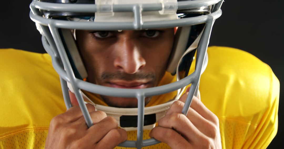 Focused Male American Football Player Wearing Helmet and Jersey - Free Images, Stock Photos and Pictures on Pikwizard.com