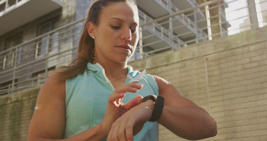 Athletic Woman Checking Smartwatch During Outdoor Workout - Free Images, Stock Photos and Pictures on Pikwizard.com