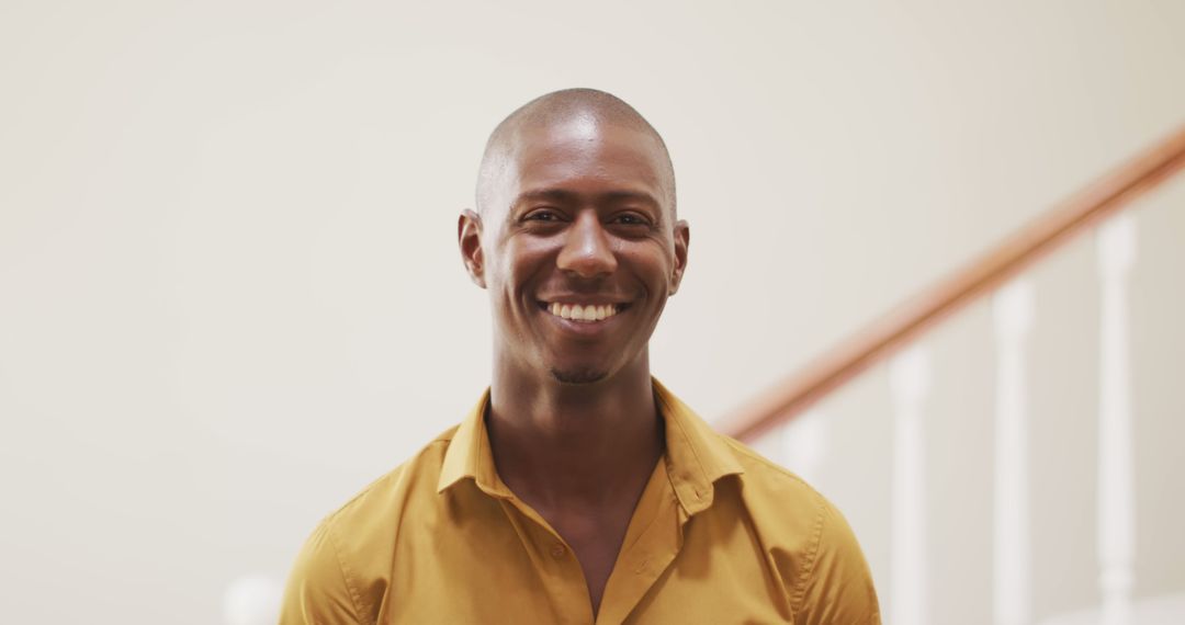 Smiling Man in Yellow Shirt Posing Indoors - Free Images, Stock Photos and Pictures on Pikwizard.com