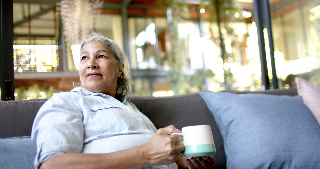 Senior Woman Relaxing with Coffee on Comfortable Sofa at Home - Free Images, Stock Photos and Pictures on Pikwizard.com