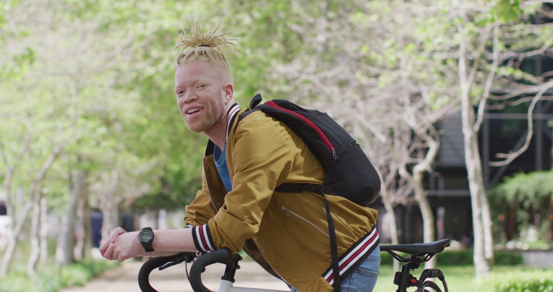 Albino Man with Dreadlocks Smiling Outdoors with Bicycle