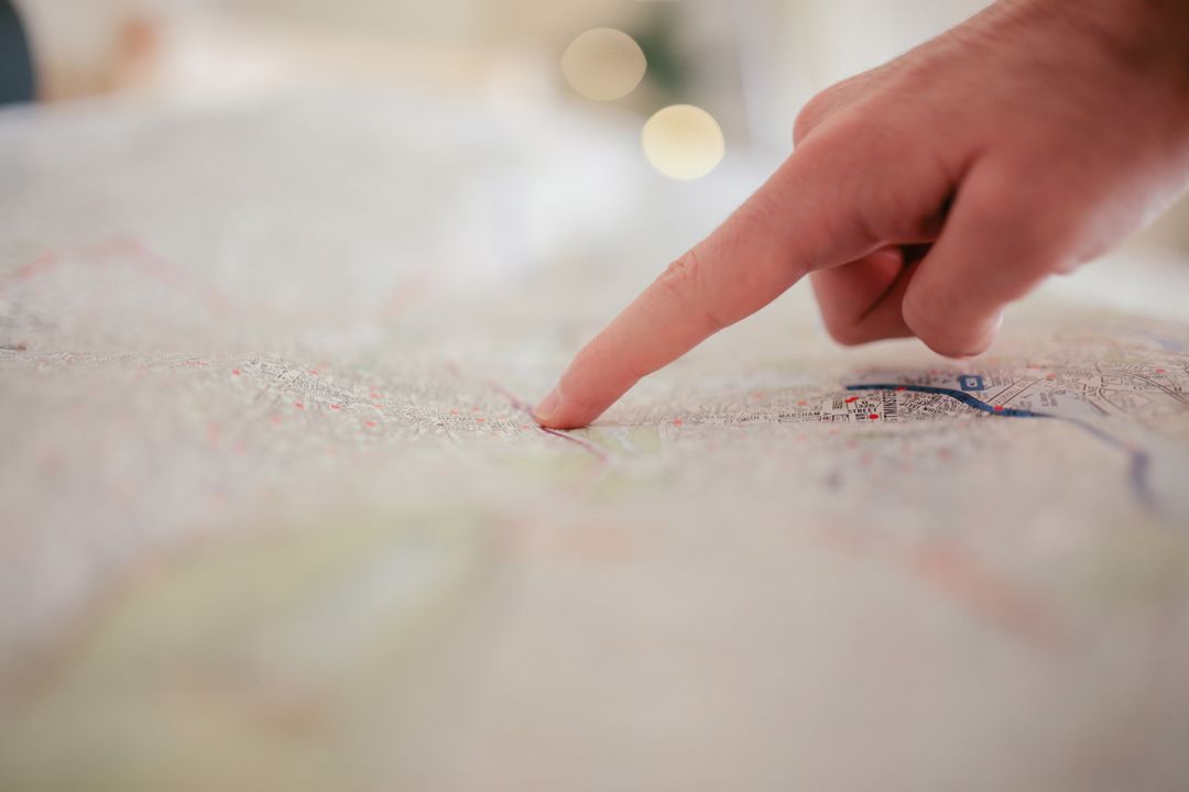 Finger pointing on paper map planning route and navigation for travel