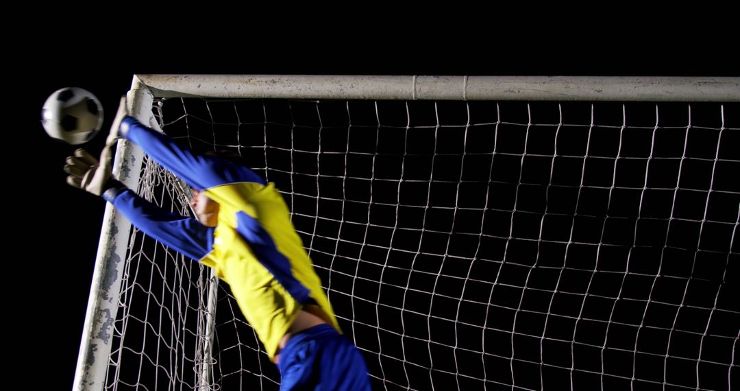 Goalkeeper Making a Save During Soccer Match at Night - Free Images, Stock Photos and Pictures on Pikwizard.com