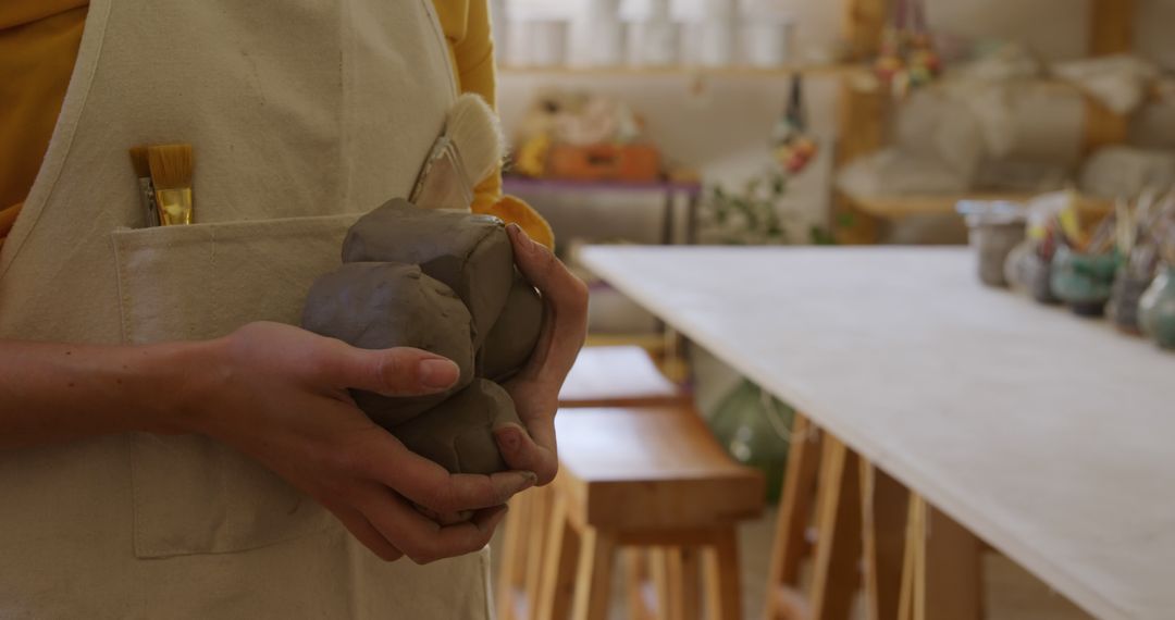 Hands Holding Clay in Art Studio with Working Table - Free Images, Stock Photos and Pictures on Pikwizard.com